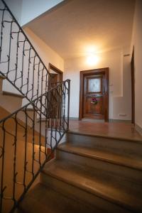 a staircase in a house with a wooden door at Appartamento centro storico Gubbio in Gubbio