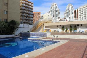 a swimming pool in a city with tall buildings at Apartamentos Viña del Mar in Benidorm