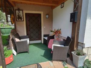 a porch with chairs and a table and a door at Hiša Jezersko in Zgornje Jezersko