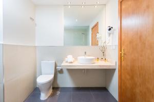 a white toilet sitting next to a sink in a bathroom at Hotel Colon Rambla in Santa Cruz de Tenerife