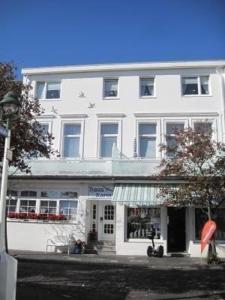 a white building with a store in front of it at Haus Meeresbrise Haus Karin in Norderney