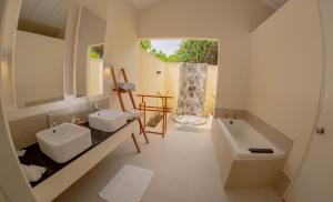 uma casa de banho com 2 lavatórios e uma banheira em Hondaafushi Island Resort em Vaikaradhoo