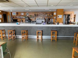 - un bar avec des tabourets en bois dans un restaurant dans l'établissement Hostal Meson Pepa, à Logroño