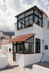 a house with black windows and a roof at Pearl of Nature: Serenity by the Sea in Azano