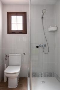 baño con aseo y ducha con ventana en Pearl of Nature: Serenity by the Sea en Azano