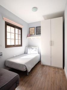 1 dormitorio con 1 cama y armario blanco en Pearl of Nature: Serenity by the Sea en Azano