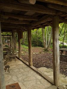 een houten paviljoen met een picknicktafel en banken bij Brvnara u planini in Petrovac na Mlavi