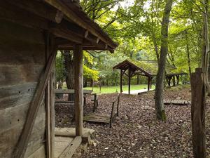 une cabane en bois avec un banc et un kiosque dans l'établissement Brvnara u planini, à Petrovac na Mlavi