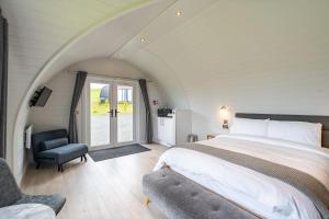a bedroom with a king sized bed and a chair at The Vu Snugs in Bathgate