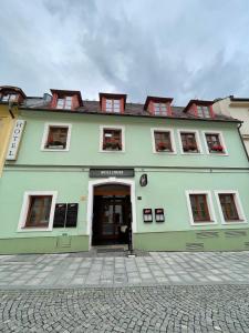 a large green building with the door open at Hotel Ennius in Klatovy