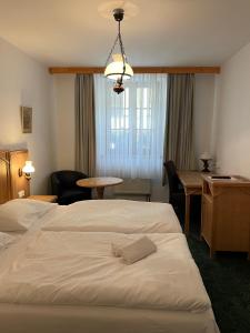 a hotel room with a bed and a desk and a table at Hotel Ennius in Klatovy