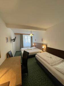 um quarto de hotel com duas camas e uma mesa em Hotel Ennius em Klatovy