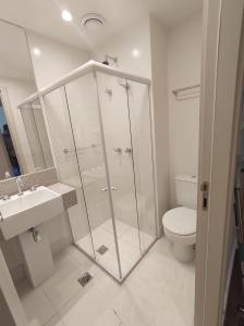 uma casa de banho com um chuveiro, um WC e um lavatório. em Apart Hotel - América Residence Campos dos Goytacazes em Campos dos Goytacazes