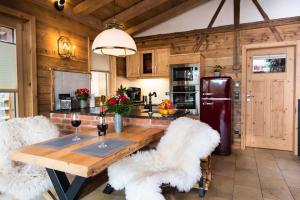 cocina con mesa de madera y sillas blancas en Bayerischer Wald Chalets, en Zwiesel