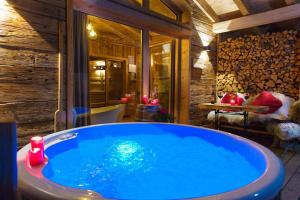 Una gran bañera azul en una habitación con mesa. en Bayerischer Wald Chalets, en Zwiesel