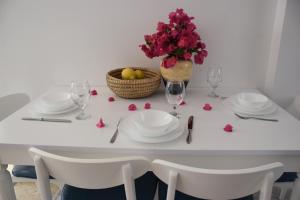 una mesa blanca con platos, copas de vino y flores en Villa Aqua en Boghaz