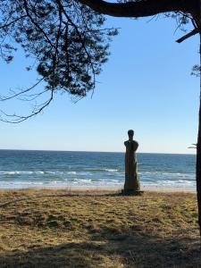 posąg kobiety stojącej na plaży w obiekcie Düne 11 w mieście Binz