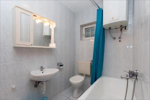 ein weißes Bad mit einem Waschbecken und einem WC in der Unterkunft Maslinov hlad in Barbat na Rabu