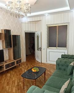 a living room with a couch and a table at Премиум квартира возле метро in Baku