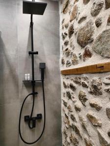 a shower in a bathroom with a stone wall at Dream Nest Meteora in Kalabaka