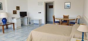 1 dormitorio con cama, mesa y TV en Hotel Selenia Residence, en Castro di Lecce