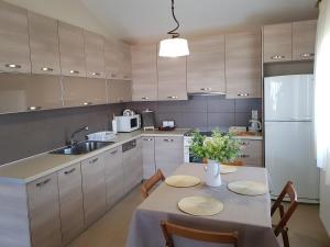 a kitchen with a table and a sink and a refrigerator at Beach house in Skala Polichnitou, Lesvos, Greece in Lisvórion