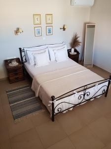 a bedroom with a large bed with white sheets and pillows at Beach house in Skala Polichnitou, Lesvos, Greece in Lisvórion
