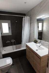 La salle de bains est pourvue d'un lavabo, d'une baignoire et de toilettes. dans l'établissement Sea view apartment in Alimos region (D4), à Athènes