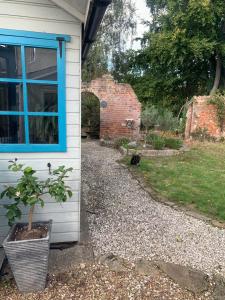 a house with a potted plant next to a window at The Cabin in Spixworth