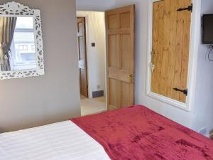 ウィンダミアにあるSlate Cottageのベッドルーム1室(ベッド1台、鏡、ドア付)