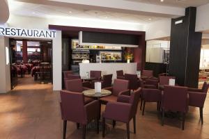 a restaurant with chairs and tables and a bar at Hôtel Florida in Lourdes