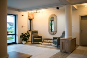 eine Lobby mit Stühlen, einem Tisch und einem Spiegel in der Unterkunft Astoria Horse Center in Gheorgheni