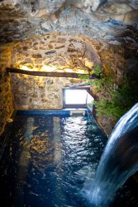 WUNDERGARTEN Private Home Spa في Gratteri: تجمع المياه في كهف مع شلال