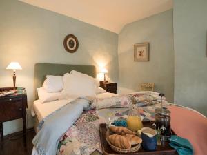 ein Schlafzimmer mit einem Bett und einem Tablett mit Essen drauf in der Unterkunft The Old Priory Cottage in Dunster