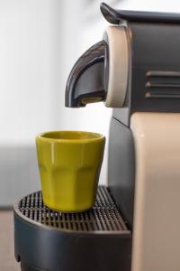 a yellow coffee cup sitting on top of a espresso machine at Appartamento centro storico Gubbio in Gubbio