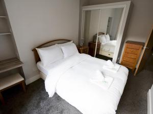 a bedroom with a large white bed and a mirror at Pass the Keys Superb 1Bed Flat in Fabulous West End in Glasgow