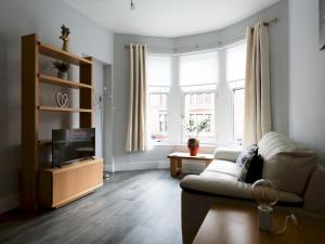 a living room with a couch and a tv at Pass the Keys Superb 1Bed Flat in Fabulous West End in Glasgow