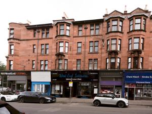 a large brick building with cars parked in front of it at Pass the Keys Superb 1Bed Flat in Fabulous West End in Glasgow