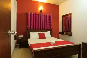 um quarto com uma cama com paredes vermelhas e uma cortina vermelha em Hotel Savonrich em Anuradhapura