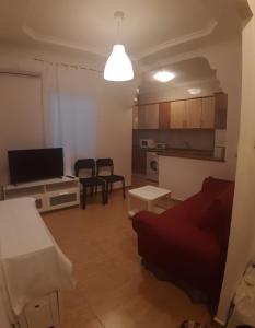 a living room with a couch and a television at Apartamento Sagunto frente a Renfe in Sagunto