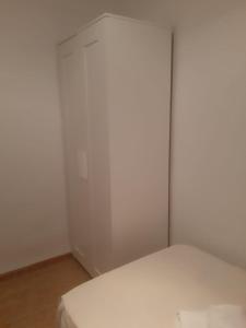 a white room with a bed and a closet at Apartamento Sagunto frente a Renfe in Sagunto