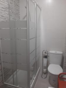 a bathroom with a toilet and a glass shower at Apartamento Sagunto frente a Renfe in Sagunto
