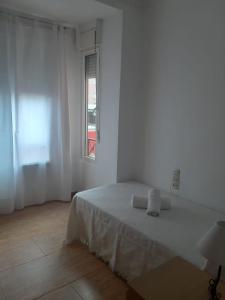 a white room with a bed and a window at Apartamento Sagunto frente a Renfe in Sagunto