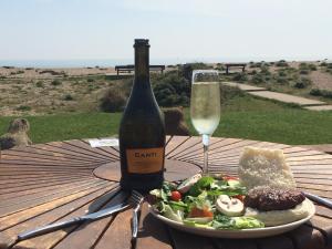 a bottle of wine and a plate of food and a glass at Pagham Getaways in Pagham