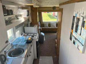 a kitchen with a sink and a stove in a caravan at Castaway retreats 4 C34 in Lincolnshire