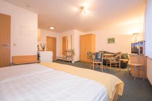ein Hotelzimmer mit einem Bett und einem Esszimmer in der Unterkunft Appartementhaus Anne in Binz