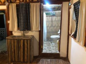 an entrance to a bathroom with a toilet and a doorway at ZIONZURI ARTS ECOVILAGE TREE HOUSE in Mbwamaji