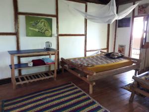 Un dormitorio con una cama y una mesa. en ZIONZURI ARTS ECOVILAGE TREE HOUSE, en Mbwamaji