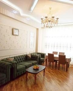 a living room with a green couch and a table at Премиум квартира возле метро in Baku