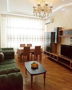 a living room with a table and a dining room at Премиум квартира возле метро in Baku